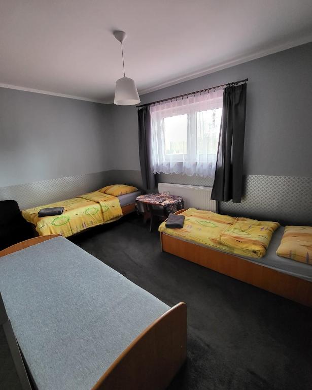 Habitación con 3 camas y ventana en Gościniec Złoty Krąg en Kobylnica