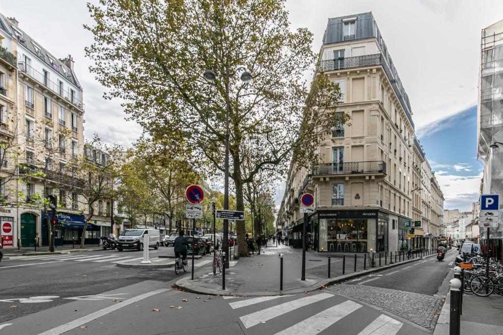 une rue de la ville avec un arbre et des bâtiments dans l'établissement MBA Splendide Appart - Popincourt Paris Centre, à Paris