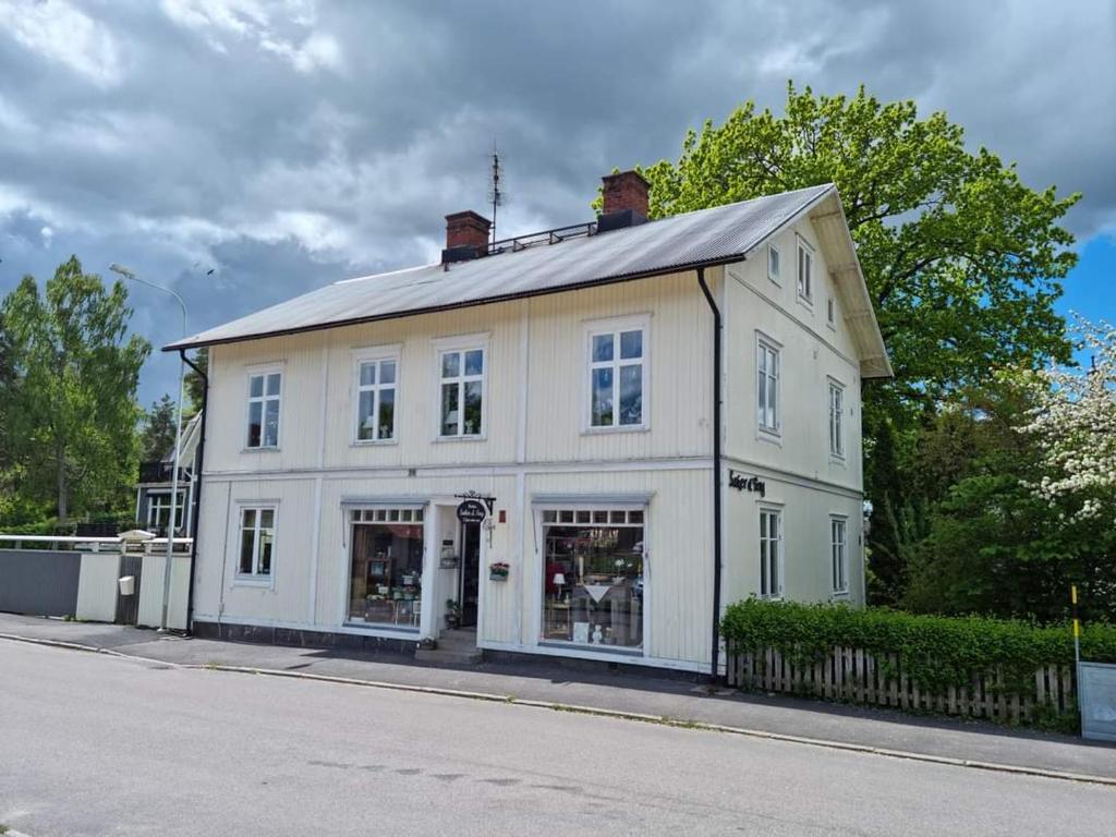 um edifício branco sentado ao lado de uma rua em Wedbergs Rum em Säffle