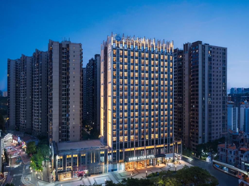 ein großes Gebäude in einer Stadt mit hohen Gebäuden in der Unterkunft Atour Hotel Meizhou West Station R&F Center in Meizhou