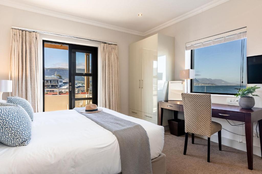 a bedroom with a bed and a desk with a computer at Harbour House Hotel in Hermanus