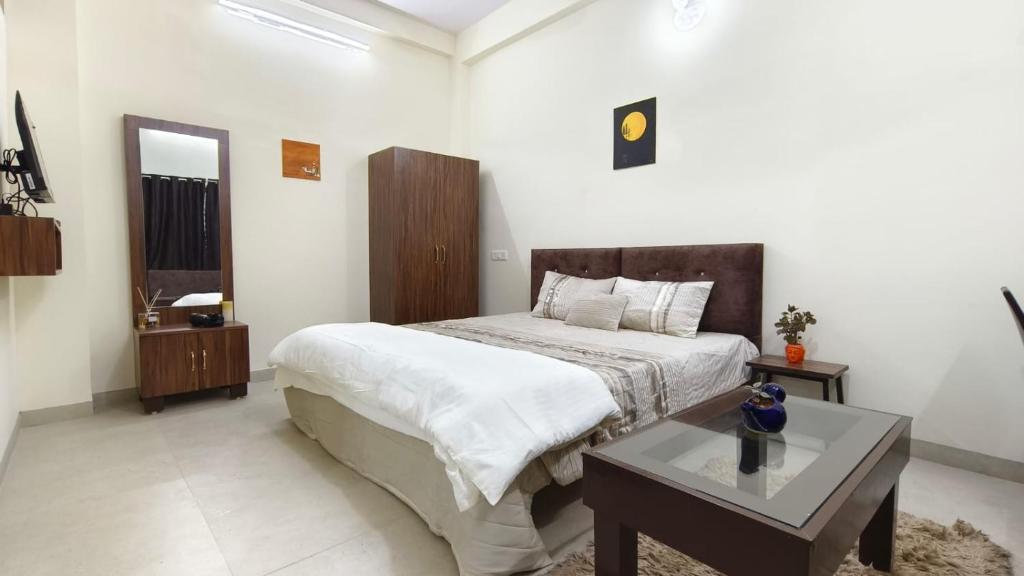 1 dormitorio con 1 cama grande y 1 mesa en Sukoon The Legacy, en Ujjain