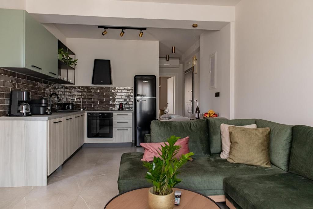 un soggiorno con divano verde e una cucina di Chelmis Sea Front Apartments - Atlantis ad Argostoli
