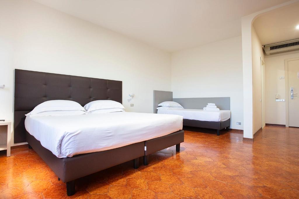 Łóżko lub łóżka w pokoju w obiekcie CDH Hotel Modena