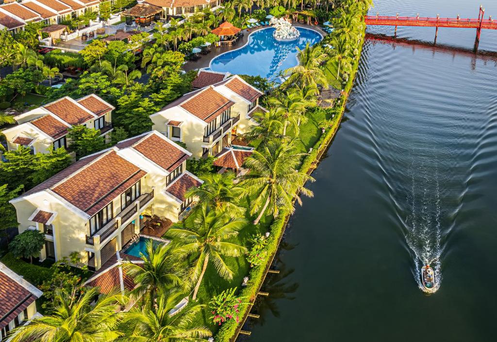 - une vue aérienne sur un complexe avec des palmiers et de l'eau dans l'établissement Koi Resort & Spa Hoi An, à Hội An