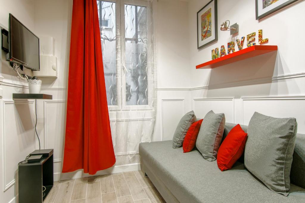 - un salon avec un canapé et un parapluie rouge dans l'établissement 25 - Fun Duplex in Montorgueil, à Paris