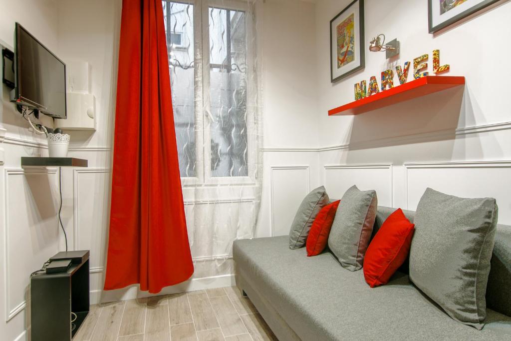 a living room with a couch and a red umbrella at 25 - Fun Duplex in Montorgueil in Paris