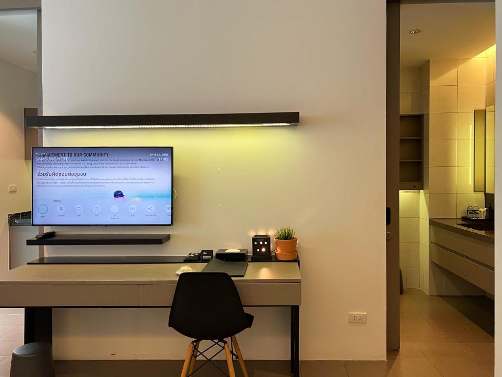 A built-in desk and smart television wall beside the kitchenette.