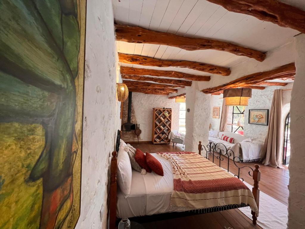 a bedroom with a bed and a painting on the wall at Atlantis 12, Maison d'hôtes et d'art in Essaouira