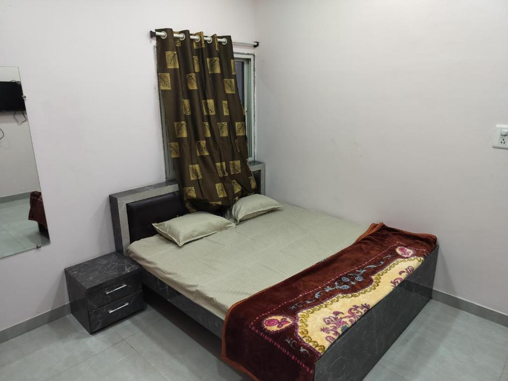 ein kleines Bett in einem Zimmer mit Fenster in der Unterkunft Shiv Shakti Homestay in Ujjain