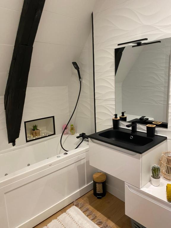 een badkamer met een zwarte wastafel en een spiegel bij Cosy & Tendance Spa in Poitiers