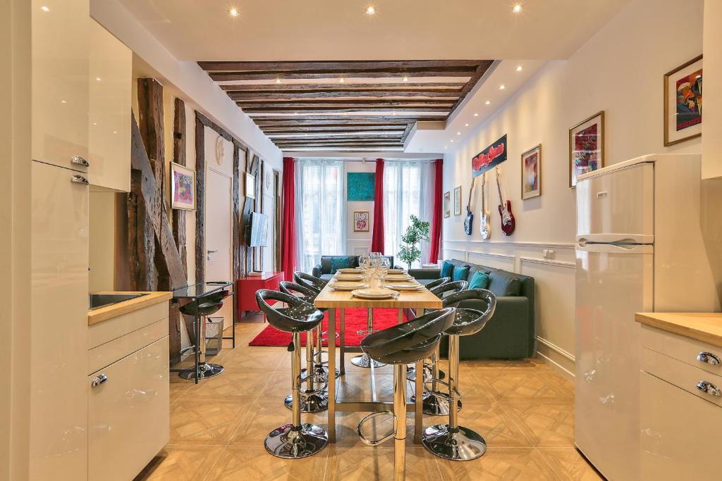 a kitchen with a table and chairs in a room at 68 - The Rolling Stones Flat in Paris