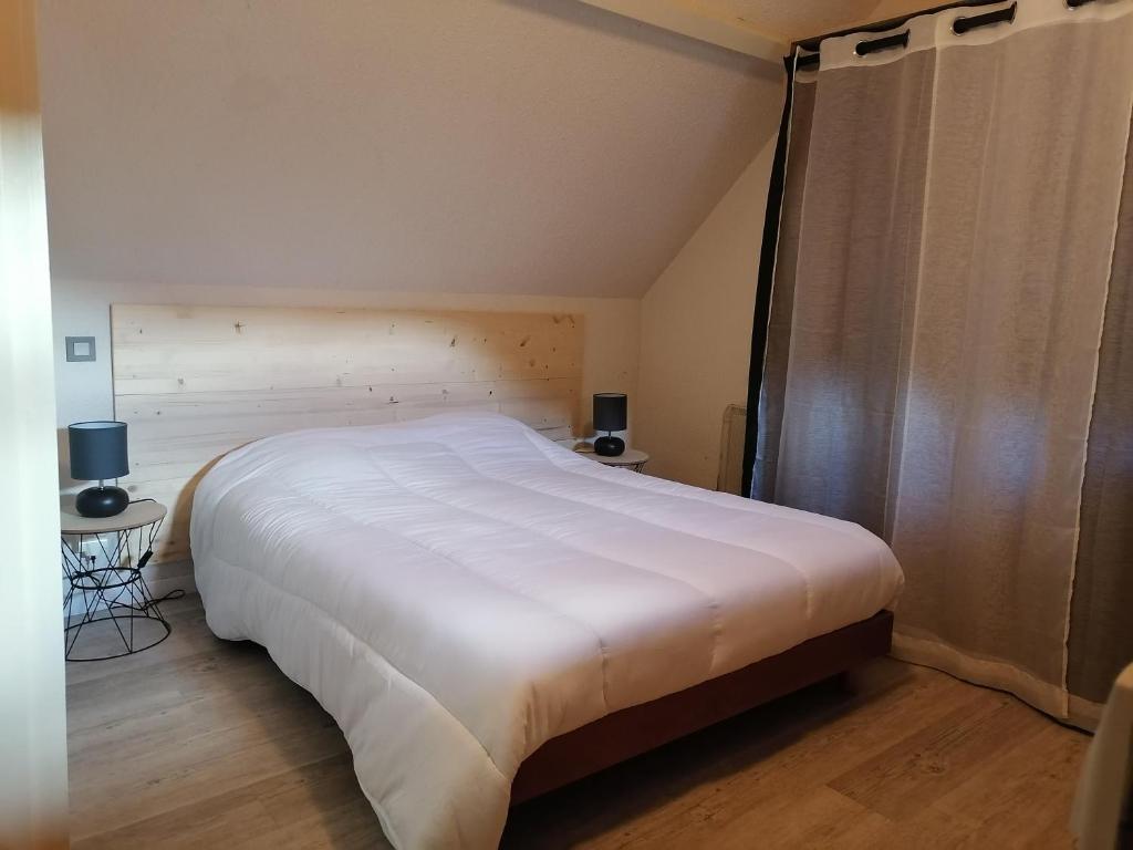 a bedroom with a large white bed in a room at Appartement Pyrénées proche la Mongie Sainte-marie de campan in Campan