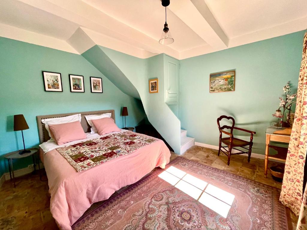 een slaapkamer met een bed met roze lakens en blauwe muren bij Maison Consulaire Chambre d hote de charme in Valros