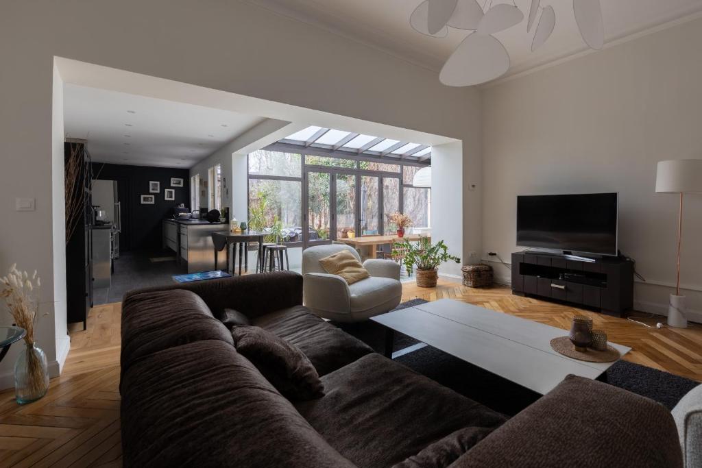 a living room with a brown couch and a tv at Les Bahamas - Piscine - Centre - 16p - Rêve au Mans in Le Mans