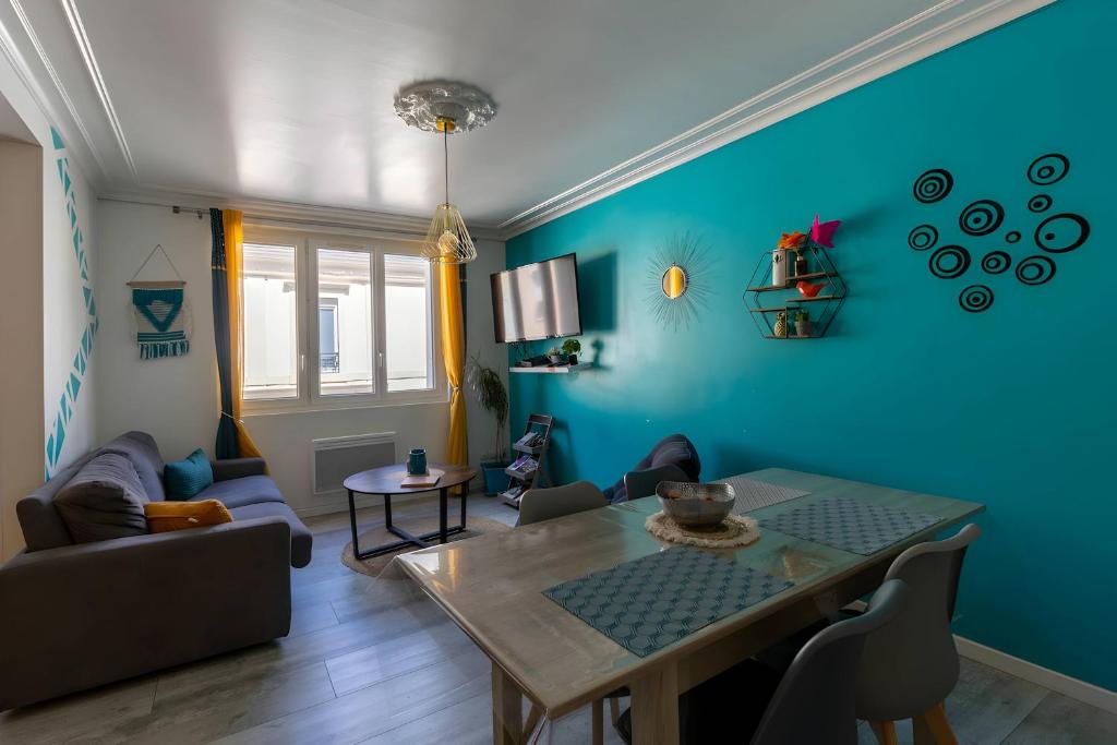 a living room with a table and a blue wall at Le Paradis Manceau - Centre - 6 pers - Rêve au Mans in Le Mans