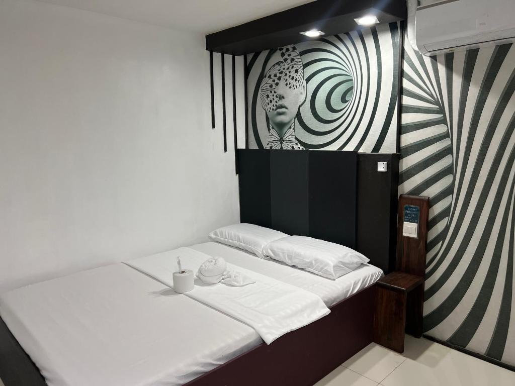 a room with a bed with a black and white wall at Quinn Dormittelle in Manila