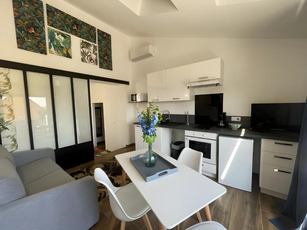 a kitchen and living room with a white table and chairs at L'éxotique - Elégant - 4p - Rêve Au Mans in Le Mans