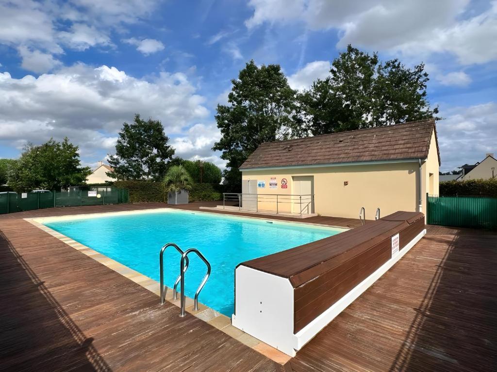 une piscine avec une terrasse en bois et un bâtiment dans l'établissement Aquatique - piscine - 5pers - Rêve au Mans, au Mans