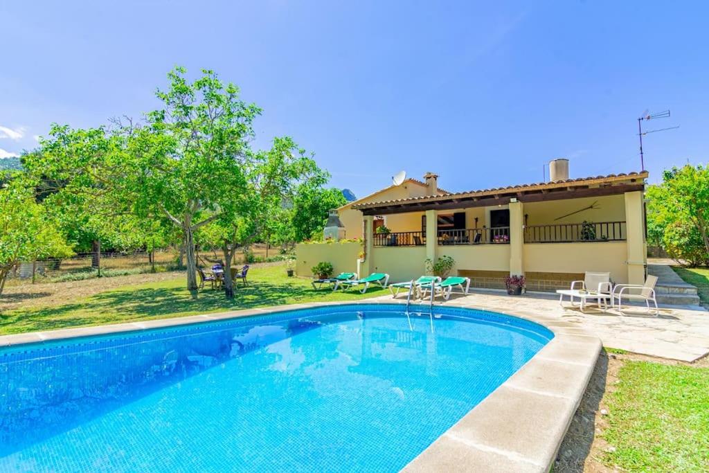 a villa with a swimming pool in front of a house at Can Pep, chalet con piscina en Pollensa in Pollença