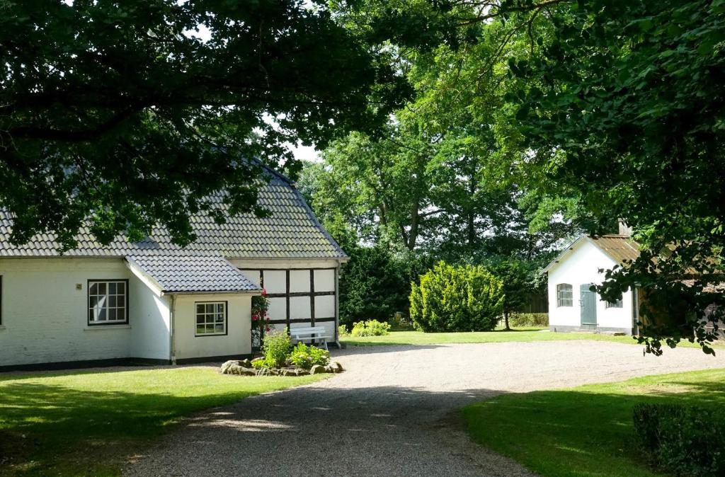 une maison blanche avec un garage et une allée dans l'établissement Altes Komödienhaus - Schloss Gelting, à Gelting