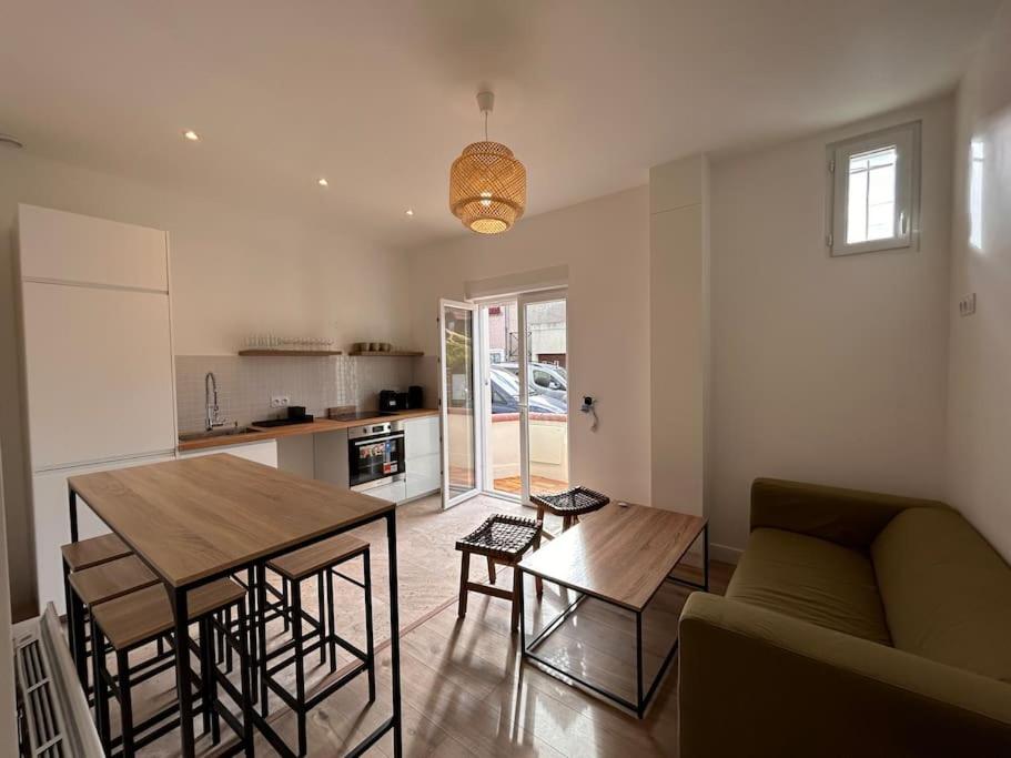 sala de estar con mesa y sofá en Appartement 4 lits • Tout neuf, en Montreuil