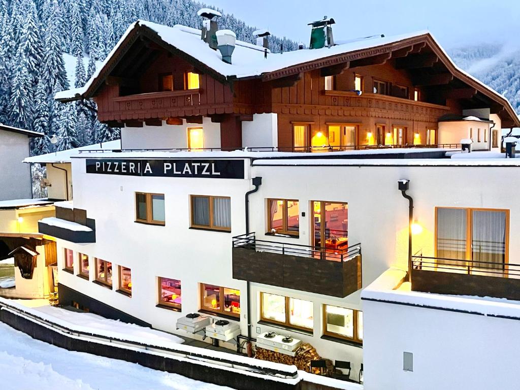 un hotel en las montañas con nieve en Aparthotel Dorfplatzl Garni en Tux