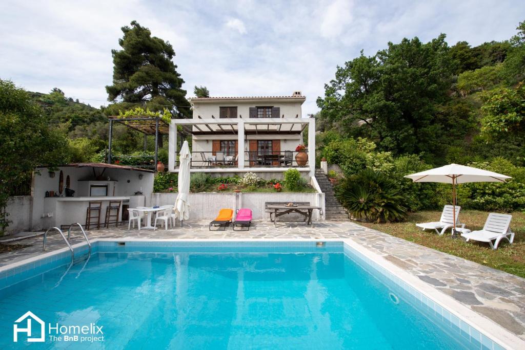 a villa with a swimming pool and a house at Villa VERA - private villa for 8 guests with pool in Kymi
