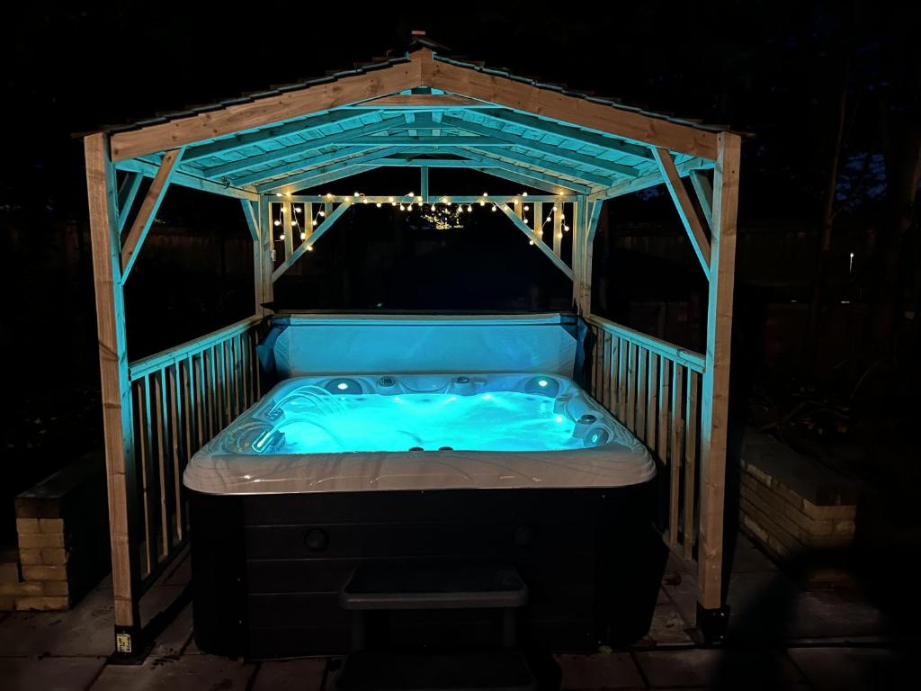 a hot tub in a wooden gazebo at night at Cross Lane Cottage in Pudsey