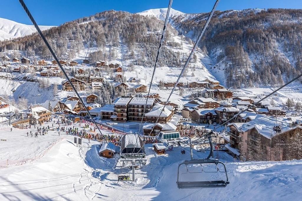 una estación de esquí con personas en un remonte en la nieve en Centre station - LA FOUX D'ALLOS - Charmant T2 en Allos