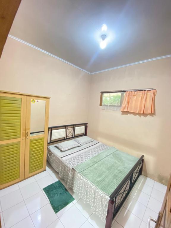 Schlafzimmer mit einem Bett und einem Fenster in der Unterkunft Villa Sunda Ciwidey in Nempel