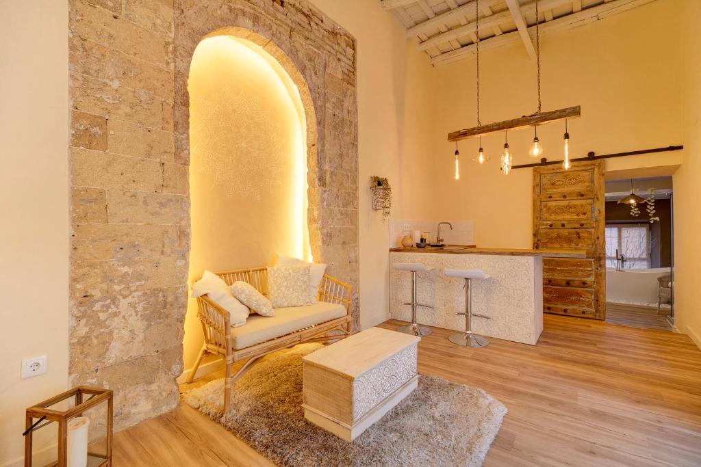 ein Wohnzimmer mit einer Steinmauer und einem Stuhl in der Unterkunft Private Spa in Kangen House Jerez in Jerez de la Frontera