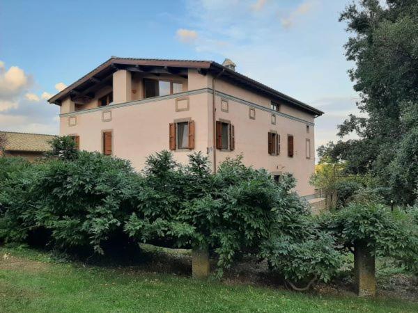 uma casa grande com arbustos à frente em Agriturismo la Romanella em Viterbo