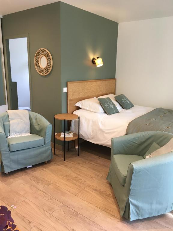 ein Hotelzimmer mit einem Bett und zwei Stühlen in der Unterkunft Studio Belle Rive in Le Pecq