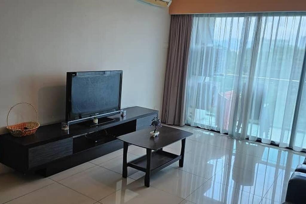 a living room with a television and a coffee table at Kinta Riverfront Homestay (Riverside) in Ipoh