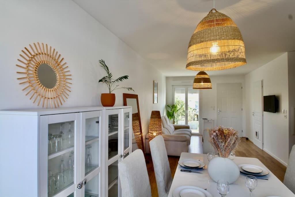 een woonkamer met een tafel en een spiegel bij Charmante maison avec piscine in Puilboreau