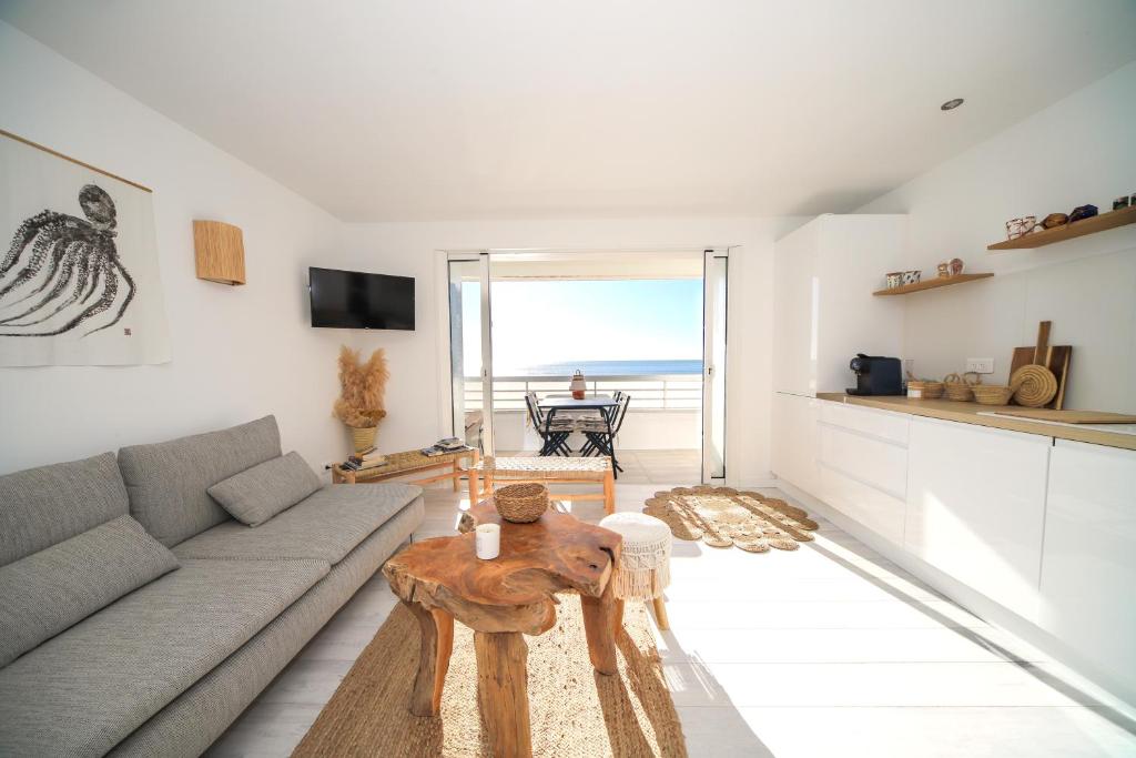 ein Wohnzimmer mit einem Sofa und einem Tisch in der Unterkunft T3 Octopus VUE MER Palavas in Palavas-les-Flots