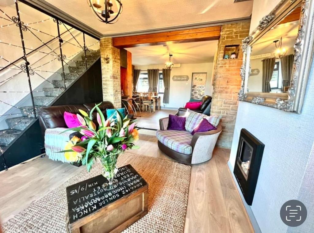 a living room with a couch and a fireplace at Wharfe View Cottage Ilkley in Ilkley