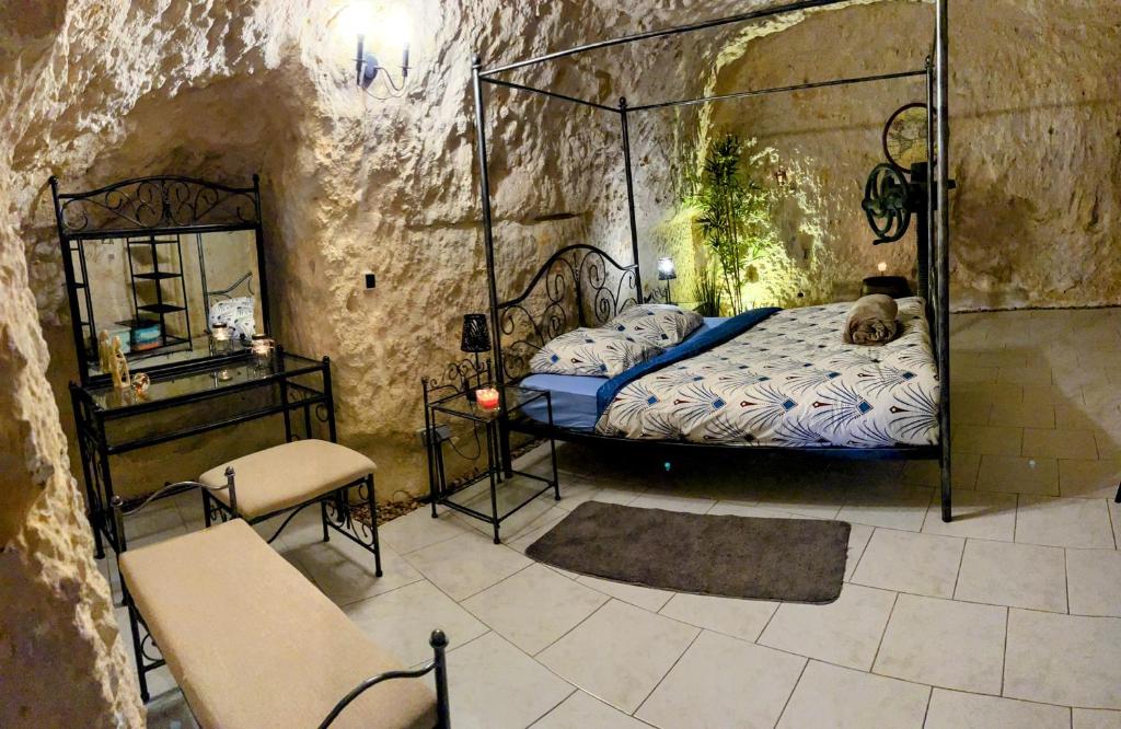um quarto com uma cama num quarto de pedra em Troglo Papillon em Luynes