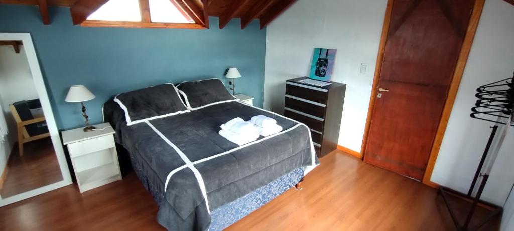 een slaapkamer met een bed, een dressoir en een raam bij Departamento Ushuaia in Ushuaia