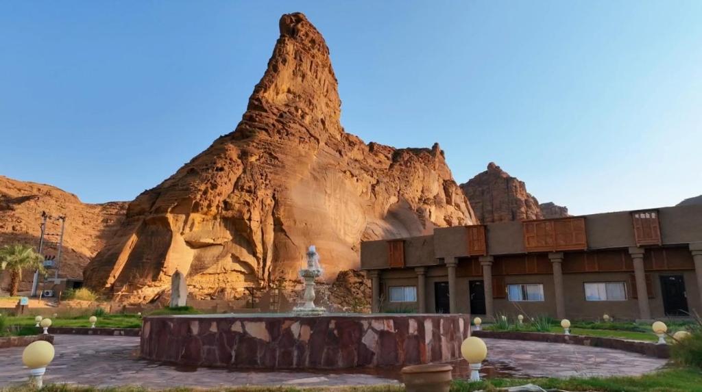 a building in front of a rock formation at Sahary Al Ula Resort in AlUla