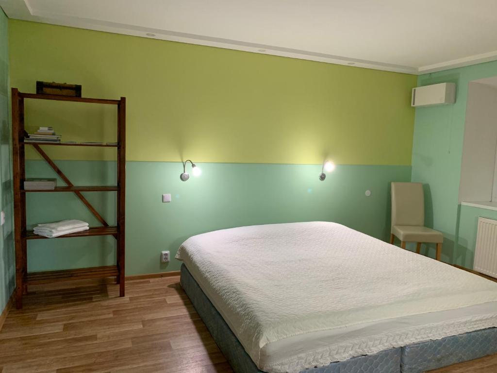 a bedroom with a bed and a green wall at Green house Ramuciai in Ramučiai
