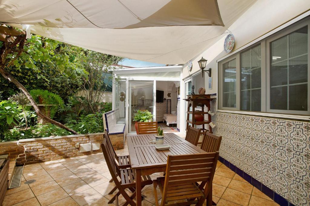a porch with a wooden table and chairs on a patio at Duplex Carmelo y Carmela in Teror
