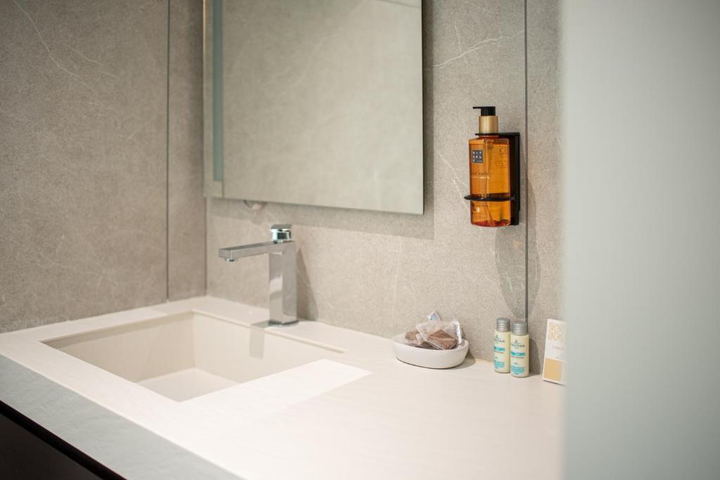 La salle de bains est pourvue d'une grande baignoire blanche et d'un lavabo. dans l'établissement Rumi Boutique Hotels&Spa Only adults, à Ascea