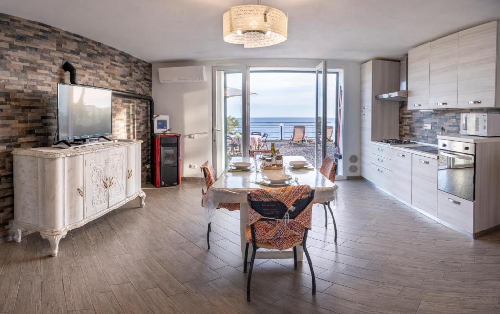 uma cozinha com uma mesa com cadeiras e vista para o oceano em casa Ciapin em Cipressa