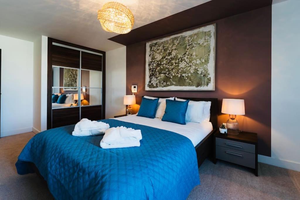 een slaapkamer met een blauw bed en handdoeken bij Marina with a view / 2 bd flat in Brighton & Hove