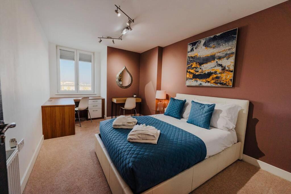a bedroom with a large bed with a blue blanket at Marina with a view / 2 bd flat in Brighton & Hove