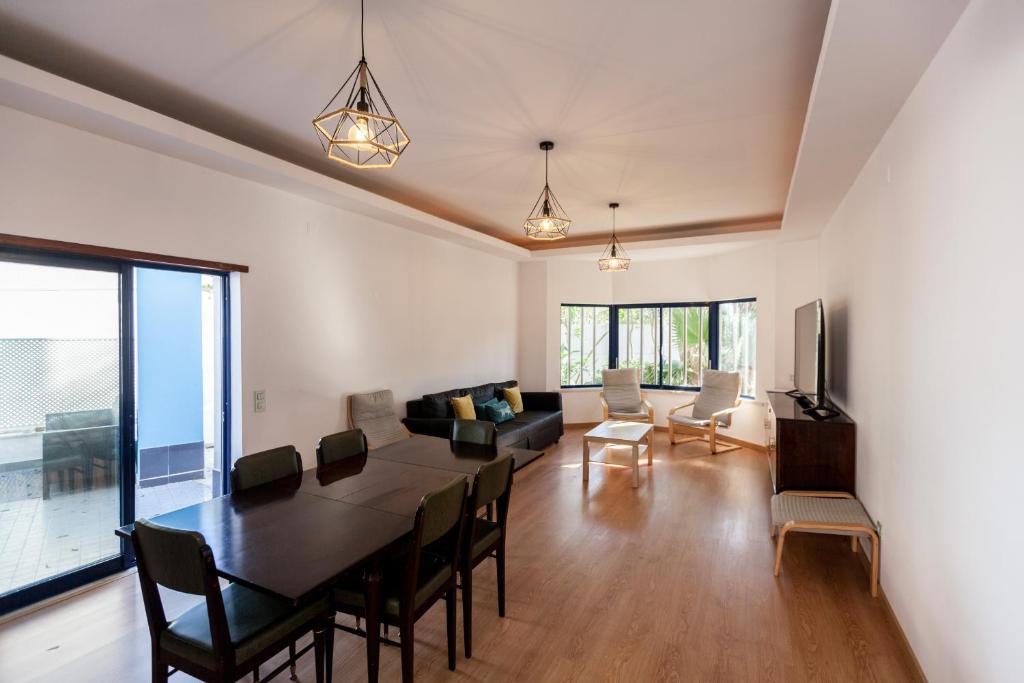 une salle à manger et un salon avec une table et des chaises dans l'établissement FLH Caparica Town House with Pool, à Costa da Caparica