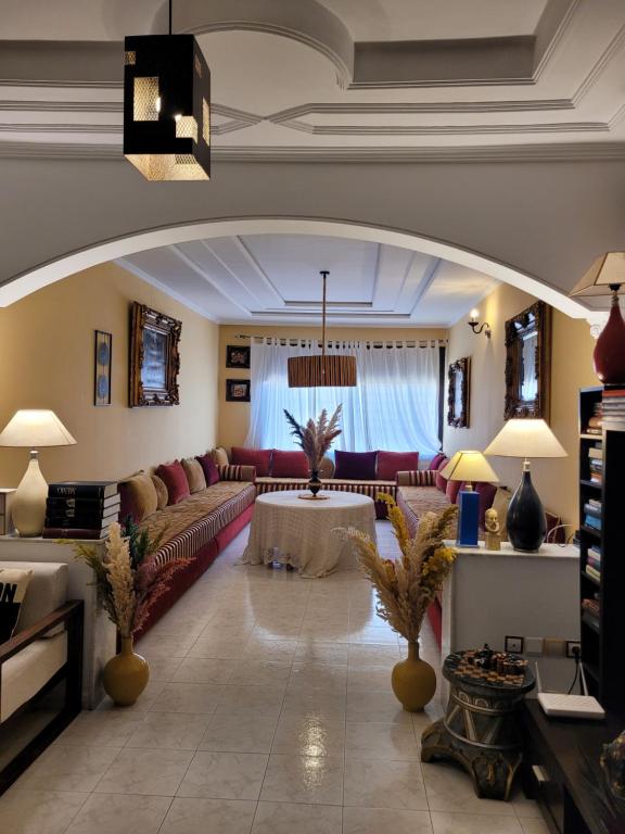 een woonkamer met een bank en een tafel bij Immeuble walili in Fès