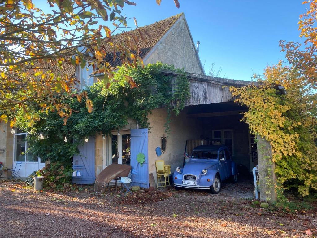 an old blue car parked outside of a house at Domaine Bleu Celeste in Couleuvre